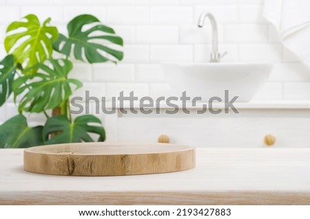 Round wooden podium for product display on blurred bathroom background Royalty-Free Stock Photo #2193427883