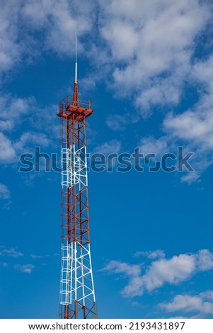 red mobile phone tower against the blue sky. High quality photo