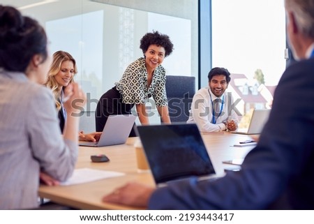 Businesswoman Leading Multi-Cultural Business Team Meeting And Collaborating Around Table In Office Royalty-Free Stock Photo #2193443417