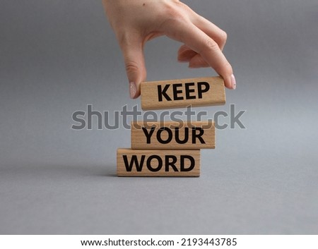 Keep your word symbol. Wooden blocks with words Keep your word. Beautiful grey background. Businessman hand. Business and Keep your word concept. Copy space.