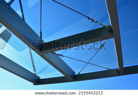 strut, suspended glass roof above the building entrance. bus station, railway station. cable wind braces. aluminum construction with windows above the pergola Royalty-Free Stock Photo #2193452213
