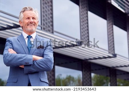 Portrait Of Smiling Senior Businessman CEO Chairman Standing Outside Modern Office Building Royalty-Free Stock Photo #2193453643
