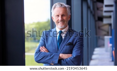 Portrait Of Smiling Senior Businessman CEO Chairman Standing Inside Modern Office Building Royalty-Free Stock Photo #2193453645