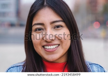 Indigenous young woman smiling while looking at camera outdoor - Focus on face Royalty-Free Stock Photo #2193458499