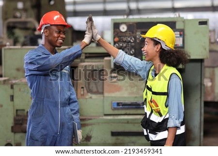 Happy smiling teamwork technician engineer or worker in protective uniform with hardhat give high five celebrate successful together completed deal commitment at heavy industry manufacturing factory Royalty-Free Stock Photo #2193459341