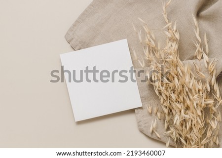 Paper mockup card with linen cloth and dry oats, top view, flat lay, beige neutral tone. Paper card with copy space for text, business brand and design