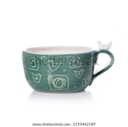 Ceramic green cup with patterns on a white background. thematic mug for photographers with pictures of cameras and birds