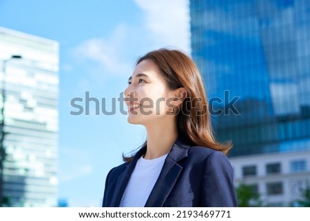 business woman standing in office district on fine day Royalty-Free Stock Photo #2193469771