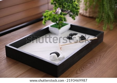 Beautiful miniature zen garden on wooden table, closeup