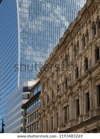 A high-angle view of a classic victorian building in a contrast with a modern commercial skyscraper in the background in the City of London
