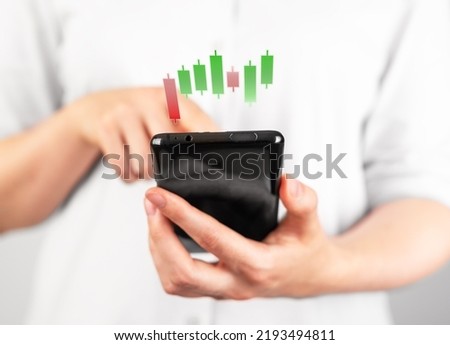 Woman using investment application on phone. Hands holding smartphone with candlestick graph. Stock value behavior analysis. Business, finance, trade concept. High quality photo