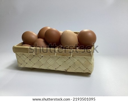 chicken eggs in a bamboo basket on a white background