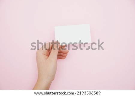  Woman holding blank business card., blank menu, discount card, business card on pink background. White Paper Card for Mockup. Mockup Design Template.                                  