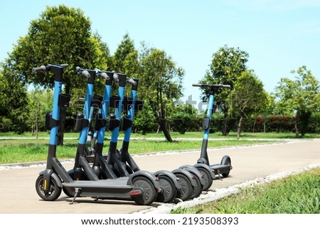 Many modern electric scooters in park. Rental service Royalty-Free Stock Photo #2193508393