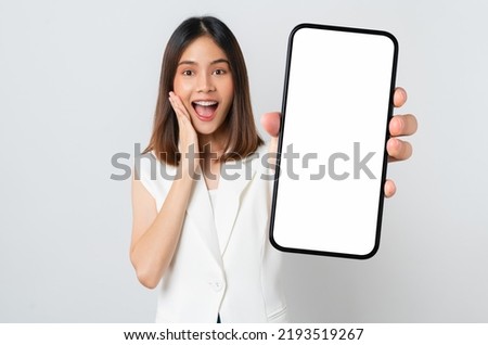 Studio shot of Beautiful Asian woman holding smartphone mockup of blank screen and smiling on white background. Royalty-Free Stock Photo #2193519267