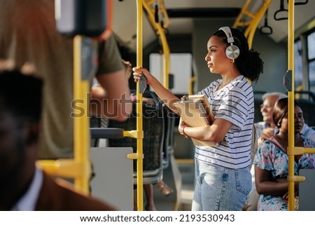 Young student is listening to music on her headphones while she's commuting Royalty-Free Stock Photo #2193530943