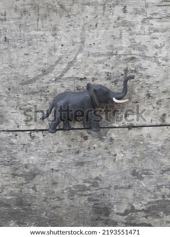 Little elephant figurine toy. Wooden background.