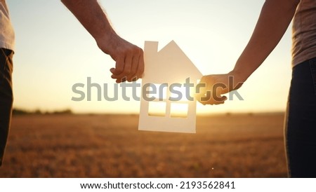 paper house happy family. friendly family hands holding paper house the glare of the sun shine through the window a beautiful sunset. mortgage business construction concept lifestyle. house dreams Royalty-Free Stock Photo #2193562841