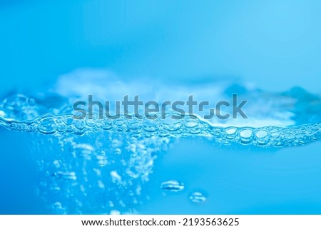 waves on the surface of clear water such as in the sea or fish tank background texture, the water is blue in color.
