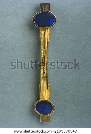 Modern stylish gold brooch jewelry on textured background