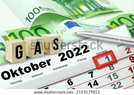 German calendar 2022 Oktober 1 and symbolic Gas on wooden cubes with 300 Euro banknotes