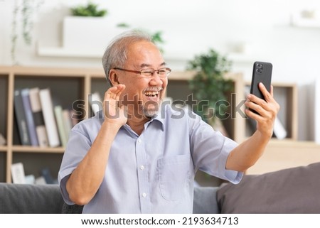 Asian elderly man making video call on smart phone, online call,  digital technology service consultation while staying at home. Smiling mature Video Call Conference talk chat online concept. Royalty-Free Stock Photo #2193634713