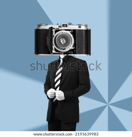 A young businessman in a black business suit headed by huge old vintage retro photo camera standing on a blue graphic background. Trendy collage in magazine style. Contemporary art. Modern design