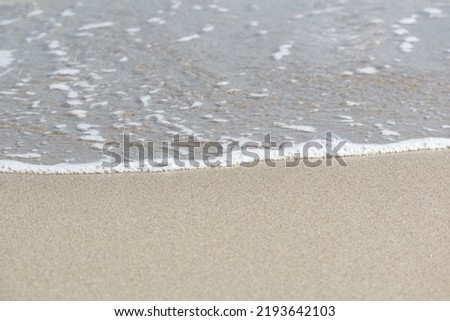 Sunny Beach Shoreline where the Ocean Meets the Light Sand Royalty-Free Stock Photo #2193642103