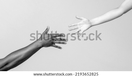 Helping hand, Rescue, multiathnic people. Helping hands, Rescue gesture. Giving a helping hand to another. Woman and african woman hand. African and caucasian hands. Black and white. Royalty-Free Stock Photo #2193652825