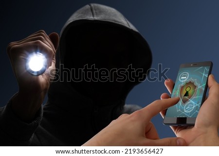 Hacker in hoodie is browsing the Internet in smartphone. protection padlock icons. Concept of cyber security and data storage