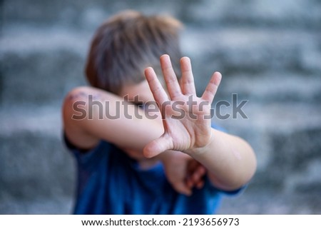 Children violence and abused concept. Child raising hands to protect itself. Royalty-Free Stock Photo #2193656973