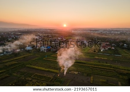 Aerial view of agricultural waste bonfires from dry grass and straw stubble burning with thick smoke polluting air during dry season on farmlands causing global warming and carcinogen fumes Royalty-Free Stock Photo #2193657011