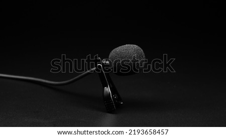 small lavalier microphone close-up on a black background