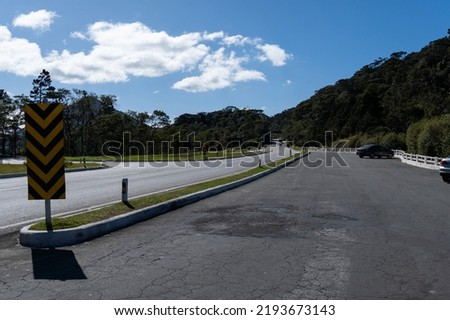 Road to Teresópolis, Rio de Janeiro, Brazil. Mountain region of the state. Signposts, cars on the highway. Region with a lot of nature. Sunny day.