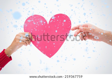 Composite image of Woman passing man pink heart with snow falling
