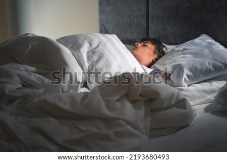 
A boy sleeps in his bed.A real scene of sleep and rest Royalty-Free Stock Photo #2193680493