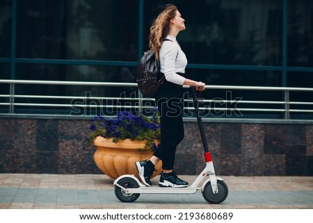 Young woman with electric scooter at the city. Royalty-Free Stock Photo #2193680689