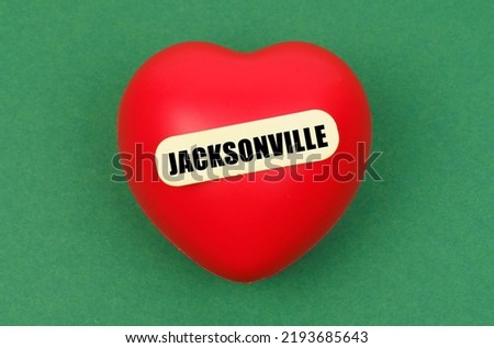 Love for the city, homeland. On a green surface lies a red heart with the inscription - Jacksonville