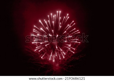 Red holiday fireworks background with sparks, colored stars and bright nebula on black night sky universe. Amazing beauty colorful fireworks display on celebration, showing. Holidays backgrounds