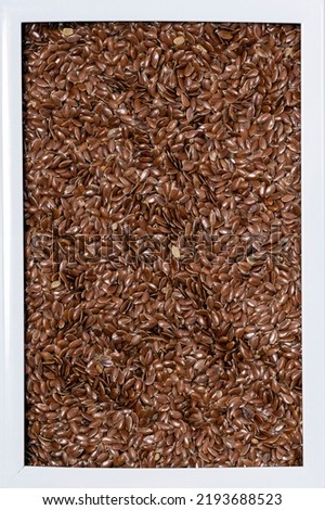 close-up macro photography of flax seeds in a white frame flat lay