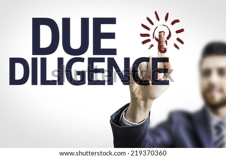 Business man pointing to transparent board with text: Due Diligence