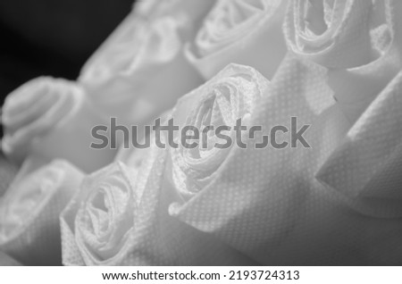 selective focus of roll of white nonwoven fabric on black background. pile of polypropylene fabric. bag industry material Royalty-Free Stock Photo #2193724313