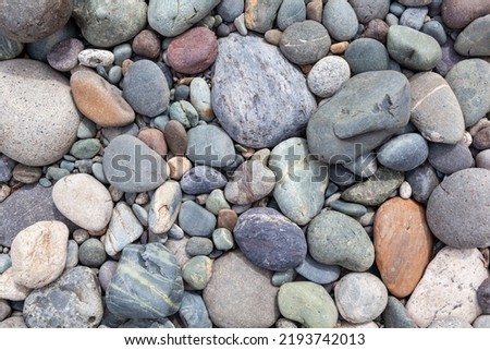 Large stones of different shapes on the riverbank close-up. there are a lot of small stones nearby. Royalty-Free Stock Photo #2193742013