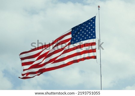 An american flag flaps in the wind on a flagpole