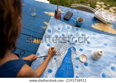Woman Artist Drawing a Blue Peacock with a pencil Close Up