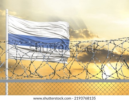 Flagpole with the flag of Altai Republic against the sky and behind a fence with barbed wire. The concept of protecting the borders of territories.