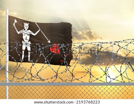 Flagpole with the flag of Blackbeard Pirate against the sky and behind a fence with barbed wire. The concept of protecting the borders of territories.