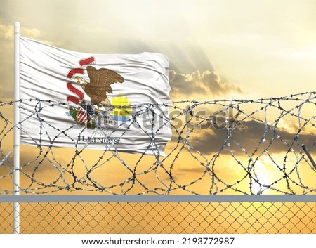 Flagpole with the flag of State of Illinois against the sky and behind a fence with barbed wire. The concept of protecting the borders of territories.