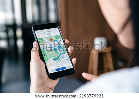 Hand of young woman searching location in map online on smartphone, Online navigator and  travel concept.