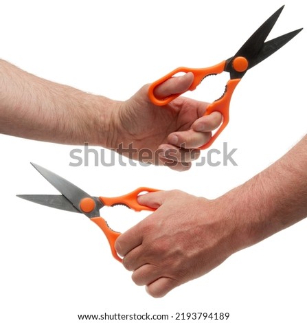 Hand with metal scissors with orange plastic handles. Isolated on white background with clipping path